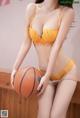 A woman in a yellow lingerie holding a basketball.