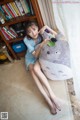 A woman sitting on the floor holding a large stuffed animal.