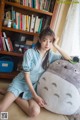 A woman sitting on the floor next to a large stuffed totoro.