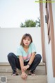 A woman sitting on the steps of a building.