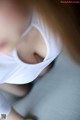 A close up of a woman's face with a white shirt on.