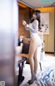 A woman in a silver bodysuit standing in a living room.