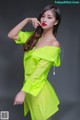 A woman in a bright green dress posing for a picture.