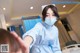 A woman wearing a face mask in a hospital room.