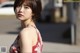 A woman in a red and white dress posing for a picture.