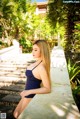 A woman in a blue bathing suit sitting on some steps.