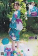 A woman in a kimono standing in a pool of water balls.