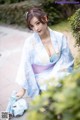 A woman in a blue kimono sitting on the ground.