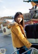 A woman standing on top of a carousel next to a car.