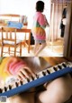 A little girl is playing a keyboard in a room.