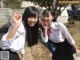 Two young women in school uniforms posing for a picture.