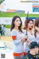 A group of women standing next to each other holding umbrellas.