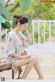 A woman sitting on a chair next to a pool.