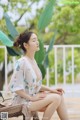 A woman sitting on a chair on a deck next to a pool.