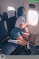 A woman sitting on an airplane looking out the window.