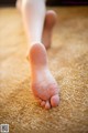 A close up of a person's bare feet on a carpet.