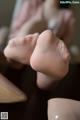 A close up of a woman's feet in high heels on a table.